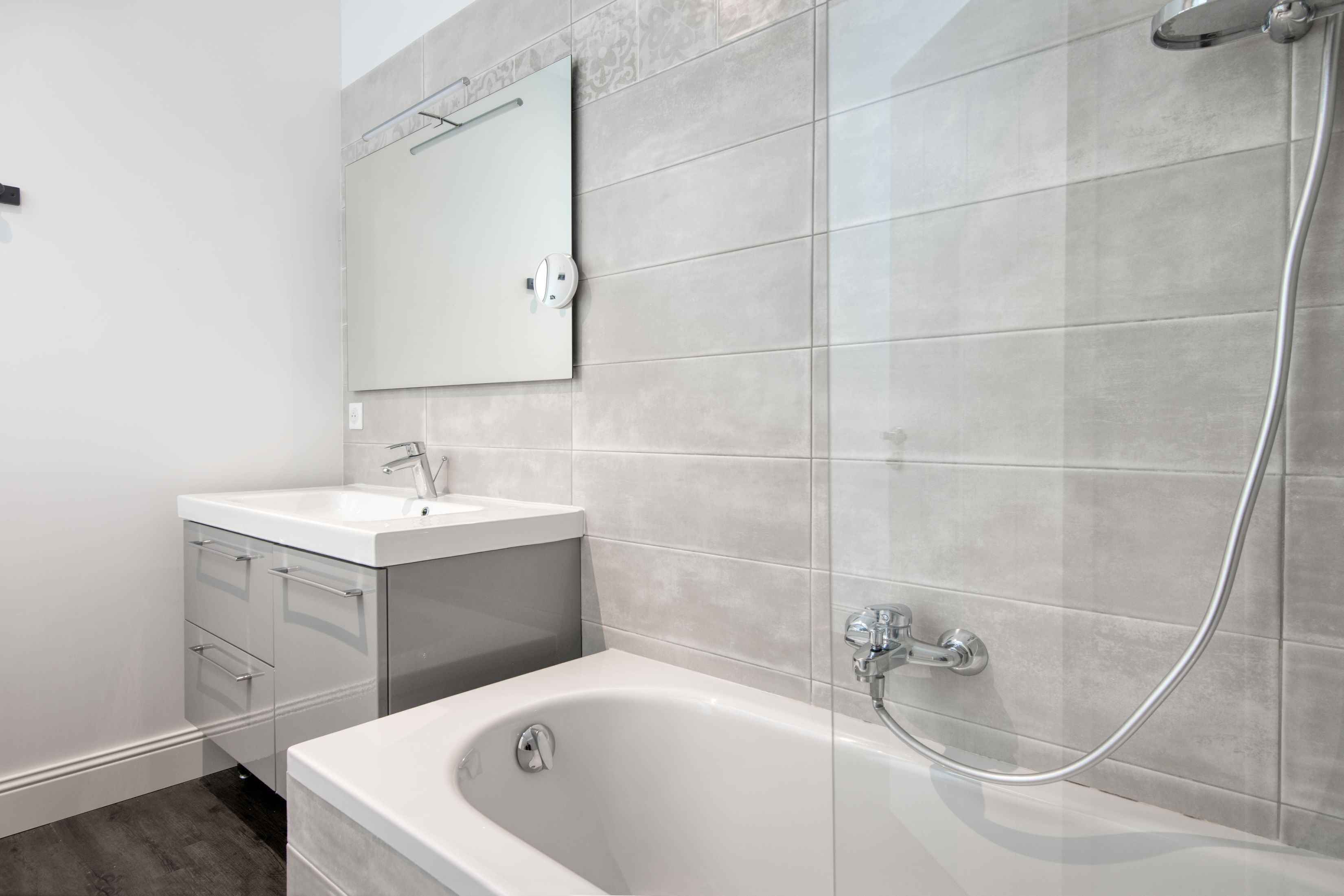 Une salle de bain moderne avec une baignoire, un lavabo et un miroir.
