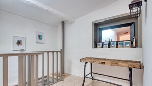 A hallway with a wooden bench, a railing, and framed pictures on the wall. - House SALICORNE    . (La Flotte)
