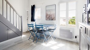 Eine moderne Küche mit Essbereich, einer Treppe und großen Fenstern.