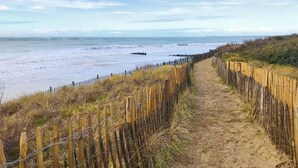 A sandy path leading to the beach, bordered by a wooden fence and barbed wire. - DUNE               . (La Couarde-sur-Mer)