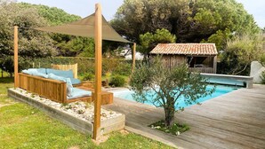 A wooden deck with a pool, a wooden pergola with cushions, and a small wooden structure in the background. - DUNE               . (La Couarde-sur-Mer)