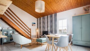 Un espace repas doté d’un plafond en bois, d’une table à manger et de chaises.