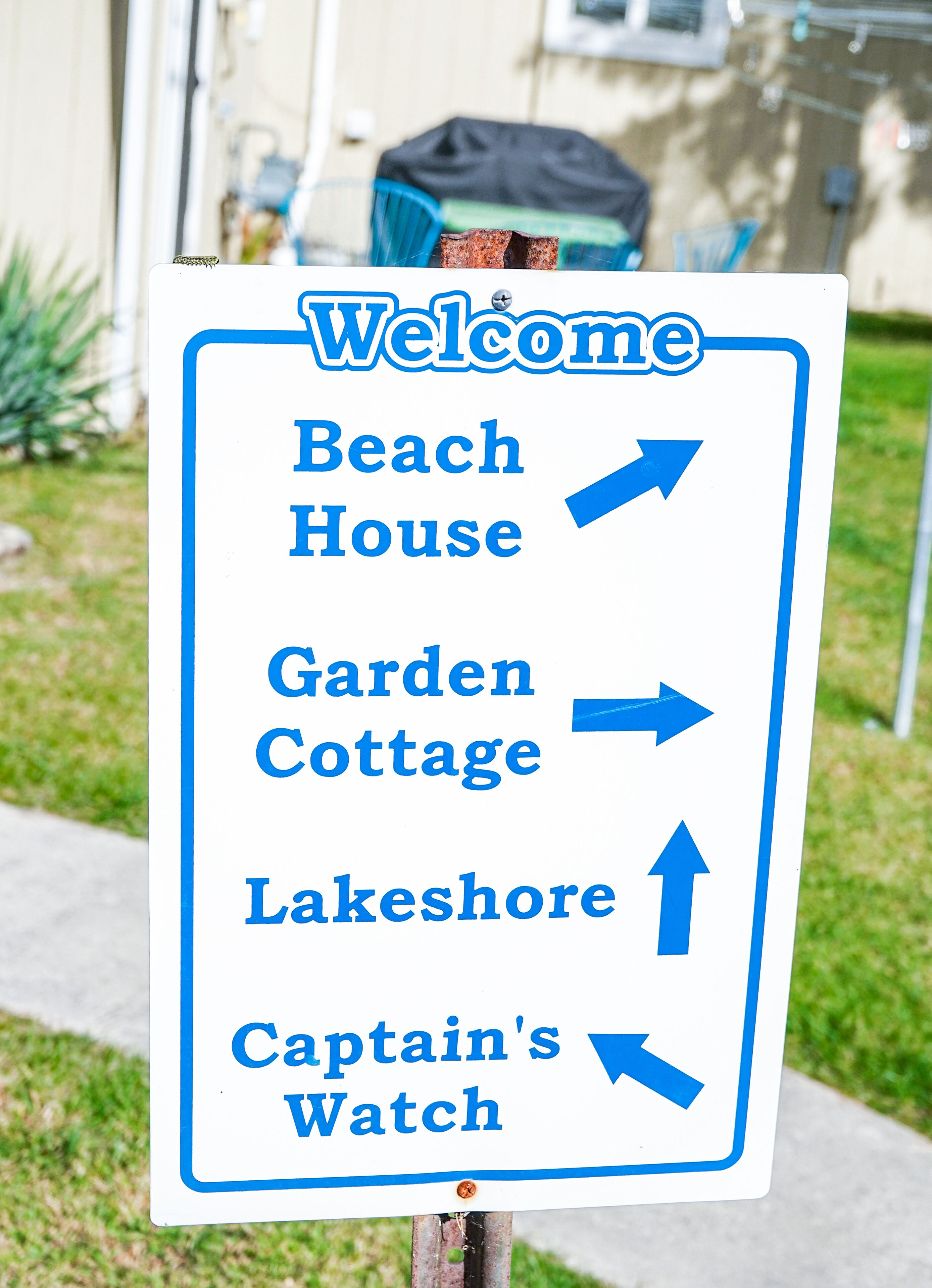 A directional sign with arrows pointing to various locations: Beach House, Garden Cottage, Lakeshore, and Captain's Watch.