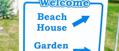 A directional sign with arrows pointing to various locations: Beach House, Garden Cottage, Lakeshore, and Captain's Watch.