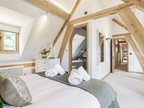 A bedroom with a bed, a dresser, a radiator, a window, and a mirror. - 3 bedroom accommodation in Alresford (Alresford)