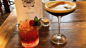 A cocktail menu and two drinks on a wooden table. - The Tayleur Arms (Telford)