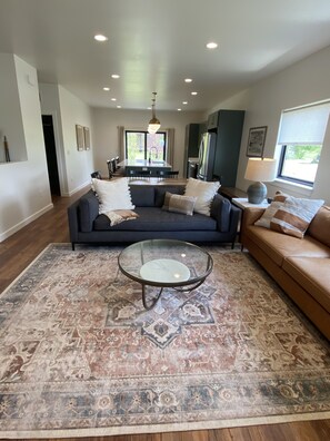 Relax in this stylish living room with a comfortable sofa, coffee table, and dining area.