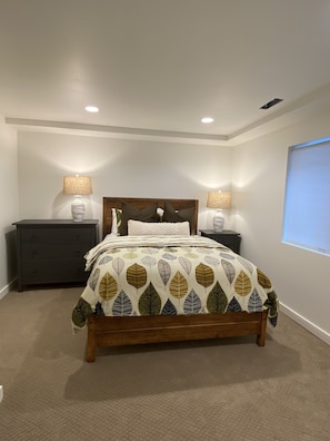 Relax in this serene bedroom with a central bed and two bedside tables, each with a lamp.
