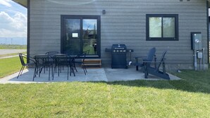 Un edificio moderno con un patio que cuenta con asientos al aire libre y una parrilla.