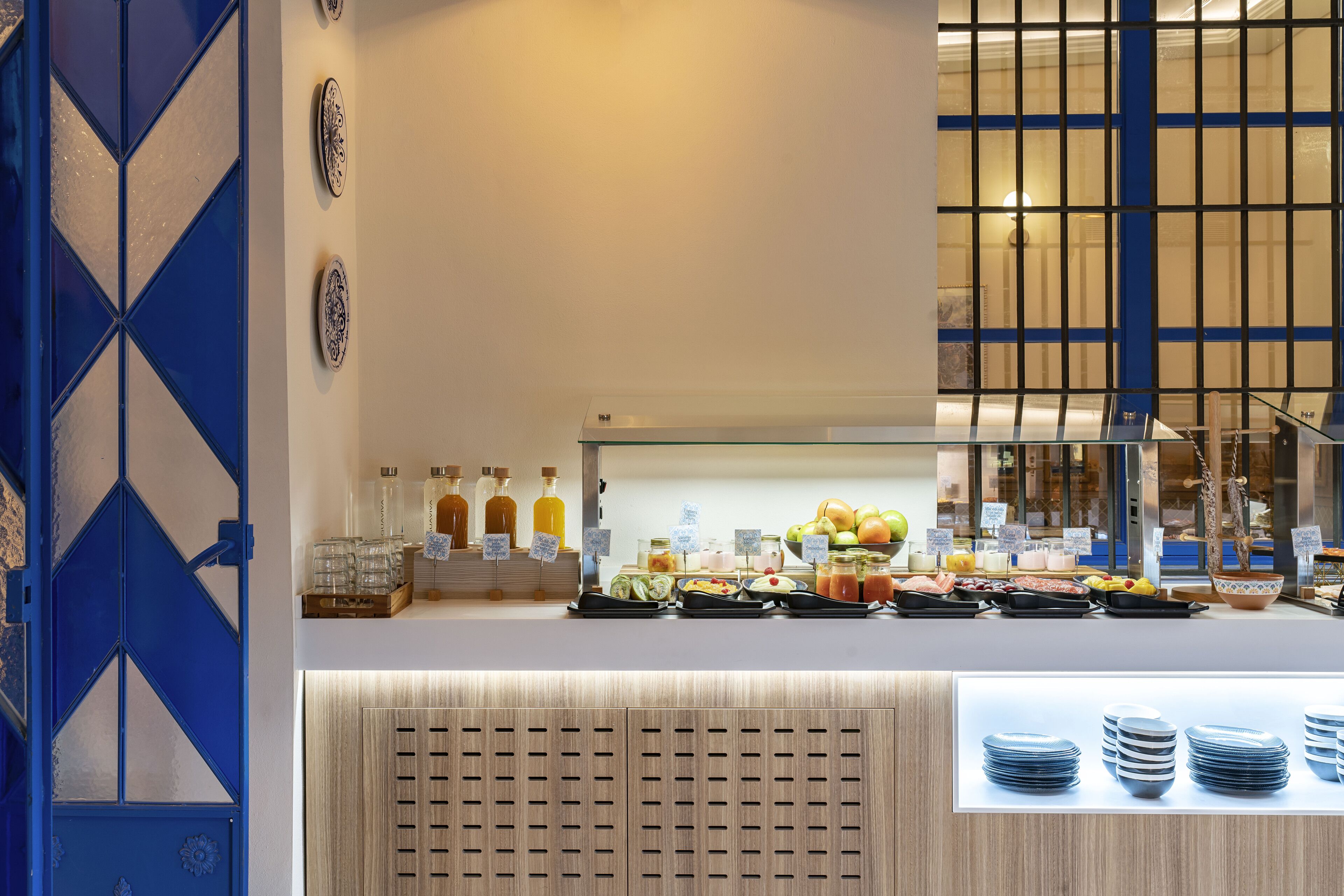 A buffet area with a variety of food items, including fruits, vegetables, and beverages.