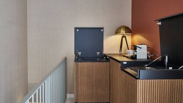 Una kitchenette compacta con cafetera, pileta y un mueble pequeño.