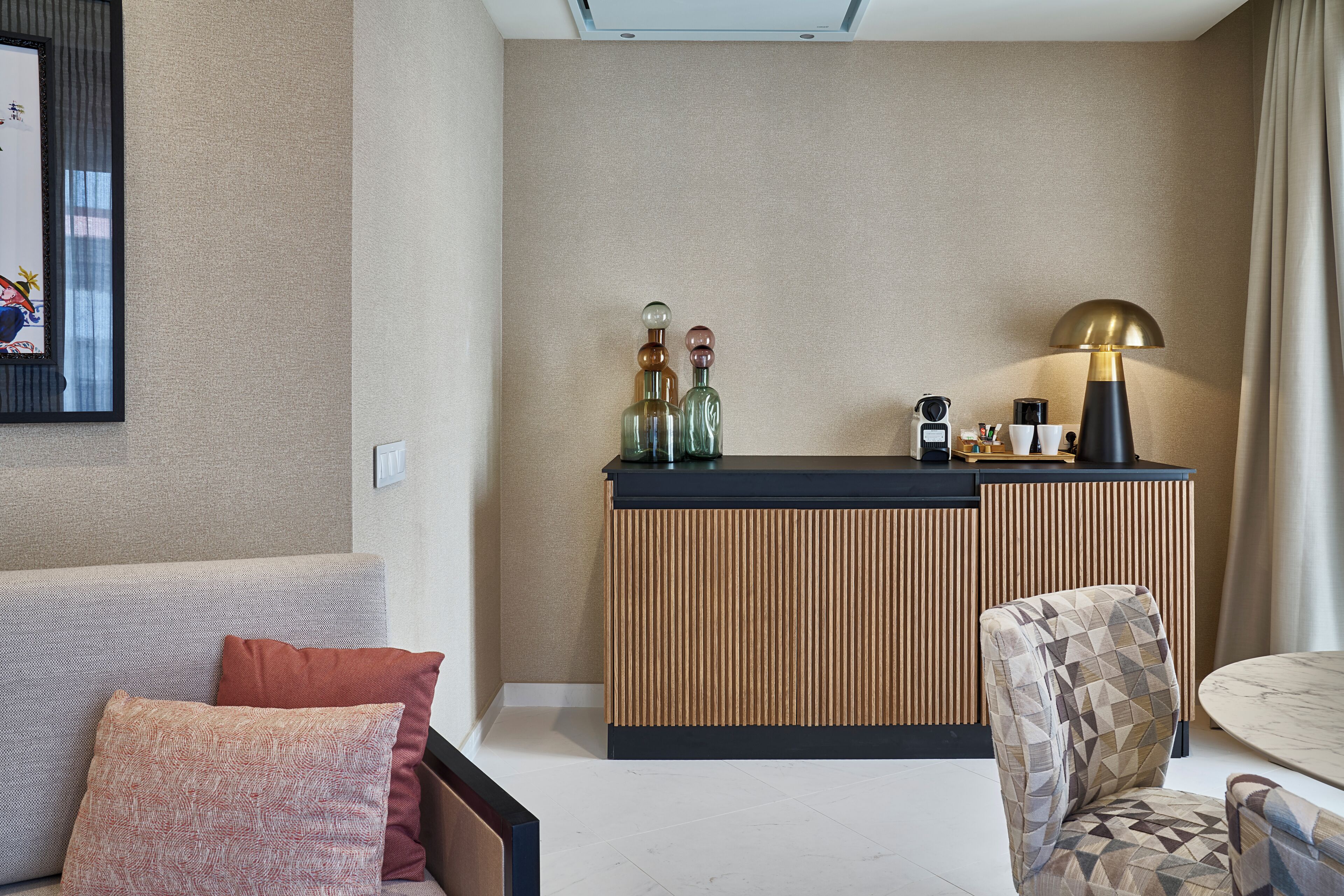 Un salon moderne avec un canapé, un fauteuil et un coin café.