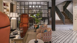 A modern lobby with a staircase, seating area, and a view of the dining area.