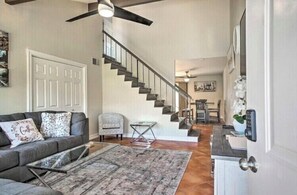 Staircase leads to an upper level, with a comfortable seating area and a clear glass coffee table.