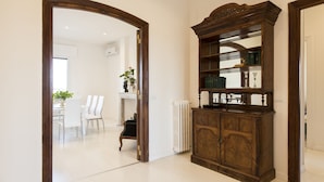 Ein Zimmer mit Holzschrank, Heizk örper und Essbereich mit Stühlen und Tisch.