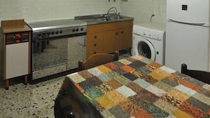 A compact kitchen with a stove, sink, and a washing machine. - A few steps from the sea (Marina di Grosseto)