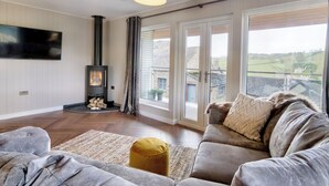 Un salon moderne avec une cheminée, un canapé, un tapis et un téléviseur.