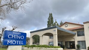 CHINO MOTEL mit freundlichem Schild, überdachter Zufahrt und der Nummer 11885 an der Fassade.