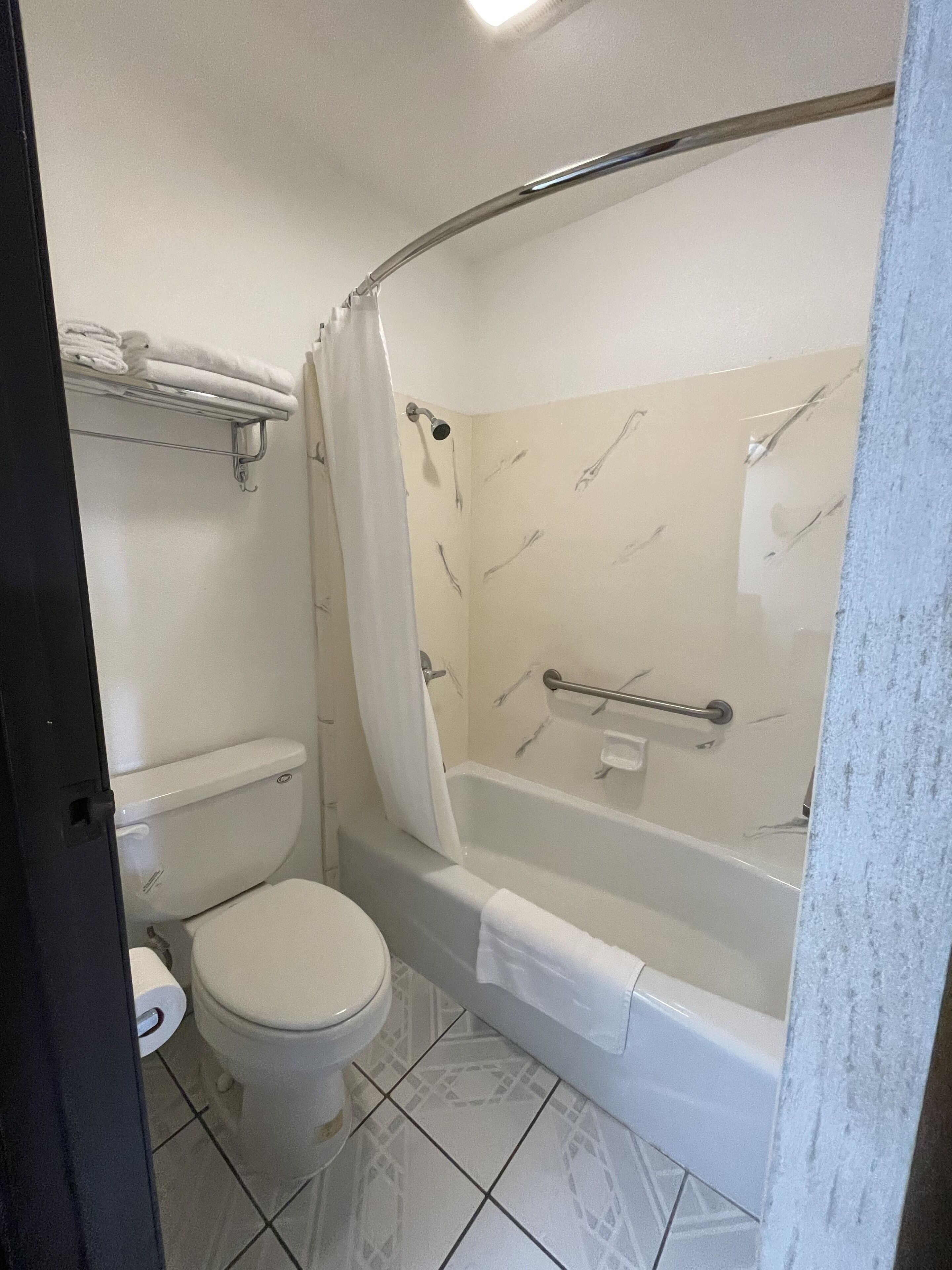 Une salle de bain équipée de toilettes, d ’une baignoire et d’un rideau de douche.