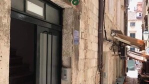 A narrow street with a building featuring a black door and a sign reading "Apartmet Niko". - Lovely 1-bed Apartment Niko in Dubrovnik (Dubrovnik)