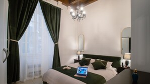 A bedroom with a bed, a laptop, a bedside table, a lamp, and a mirror. - Lovely 1-bed Apartment Niko in Dubrovnik (Dubrovnik)