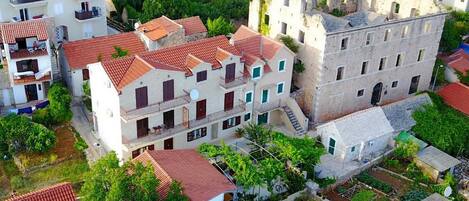 Zona residencial amb edificis d'altes plantes, terrasses de teules vermelles i abundant vegetació.