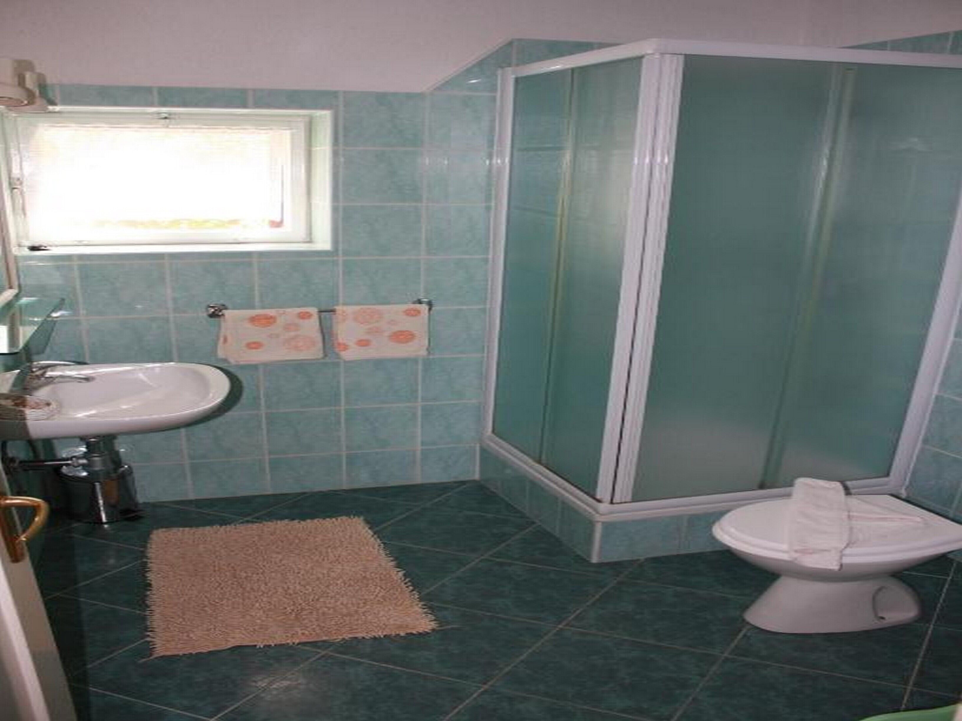Une salle de bain avec un lavabo, des toilettes et une douche.