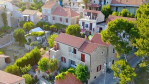 Un bâtiment de style méditerranéen traditionnel, avec un toit recouvert de tuiles rouges, des murs en pierre et un balcon.