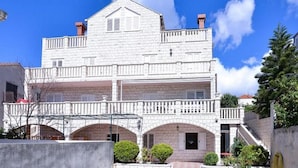 Un edificio de dos pisos con balcón y entrada abovedada.