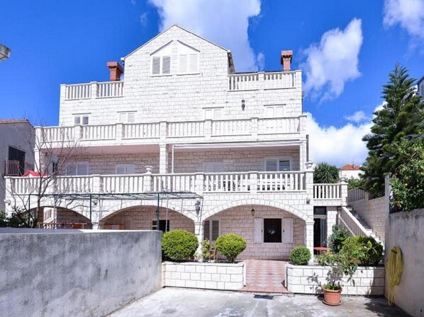 A two-story building with a balcony and arched entrance.