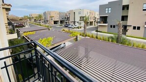 A residential area with modern buildings, a paved road, and a clear sky. - HOUSE OF THE SEA, fraction. private with pool, by car 7 minutes from the beach and downtown (Cabo San Lucas)