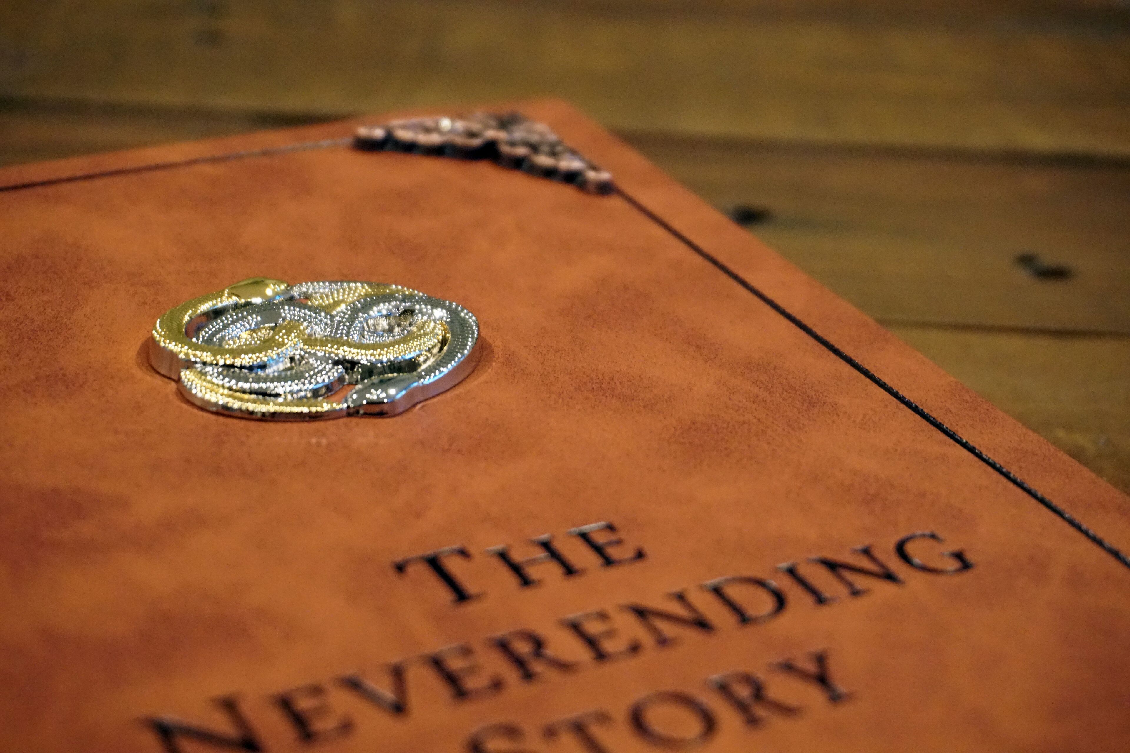 A book titled "The Neverending Story" with a decorative emblem on its cover.