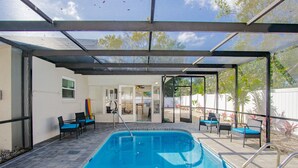 Una piscina cubierta al aire libre con sillones de descanso y un área de patio.
