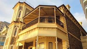 Un edificio en esquina con balcón y torre.