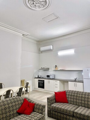 A compact living space with a kitchenette, dining area, and seating.