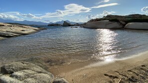 A beach with clear water, large rocks, and mountains in the background. - Superb house with sea-view terrace 300 m from the beach. (SANT AMBROGGIO LUMIO)