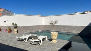 A rooftop pool area with lounge chairs, a small pool, and potted plants. - Casa Lupita (Bolaños de Calatrava)