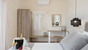 Une chambre d’hôtel comprenant un lit, une table de chevet, un bureau, un miroir et un luminaire suspendu.