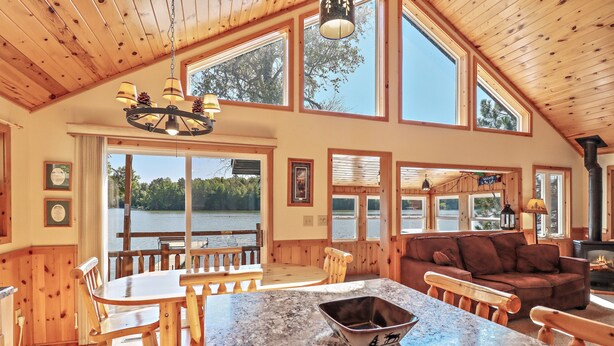 A spacious cabin with a large dining area, a cozy living room, and a fireplace.