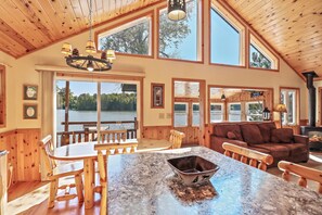 A spacious cabin with a large dining area, a cozy living room, and a fireplace. - Stepaway Vacation Rentals - Carefree Creek Cabin (Saint Germain)