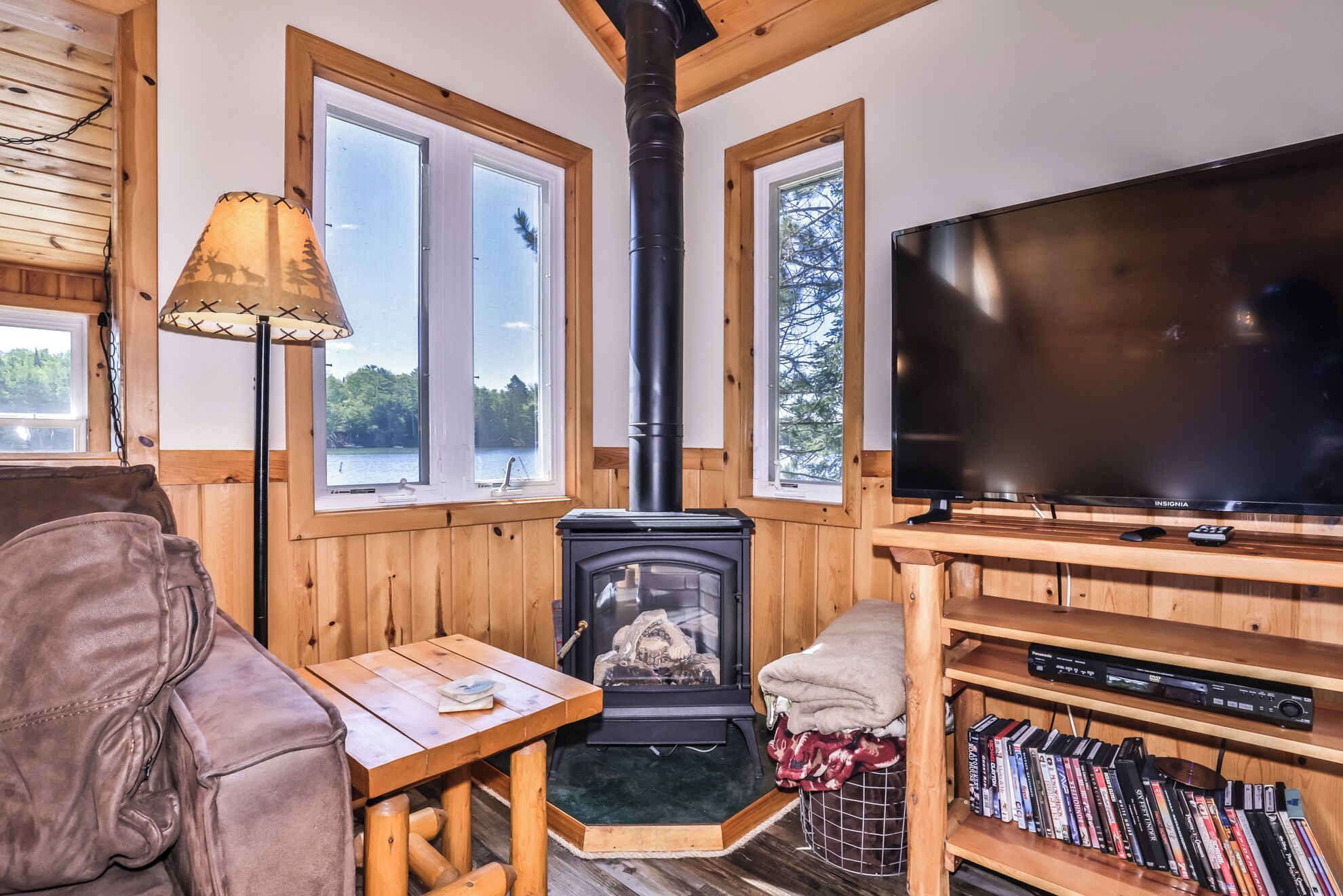 Interior acogedor de una cabaña con chimenea, muebles de madera y televisión.
