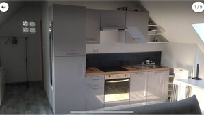 A compact kitchen with a built-in oven, a sink, and a window above the countertop. - Comfortable apartment with garden access and weights room (Mardié)