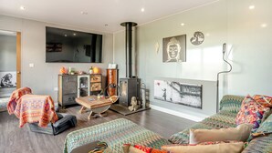 A modern living room with a sofa, a coffee table, a fireplace, and artwork on the walls. - 2 bedroom accommodation in Altham (Altham)