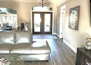 Relax in this stylish living room with a plush sofa, glass coffee table, and beautiful artwork.