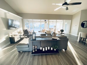 Relax in this stylish living room with a sofa facing a glass door leading to an outdoor area.