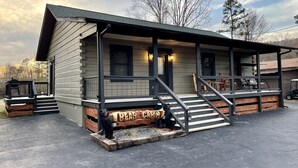 A cabin-style building with a porch, wooden steps, and a sign reading "BEAR CABIN." - Bear Cabin - Close to Magic Springs, Off-Road Park (Hot Springs)
