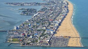 An aerial view of a coastal city with a long beachfront, dense urban area, and a pier extending into the water. - Sunset Beach Bliss| Walk to Beach & Waterpark (Ocean City)
