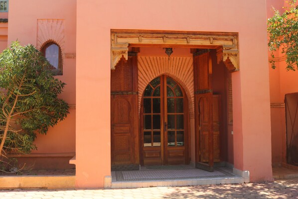 A traditional wooden door with an arched window and a small balcony.