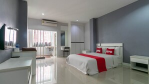 A modern hotel room with a large bed, a desk, and a TV. - Pandora House Pattaya (Pattaya)