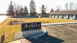 Señal del Motel Ashley, con un estacionamiento y un edificio al fondo.